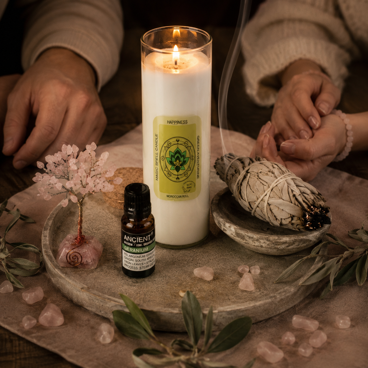 Gemeinsames Ritual mit dem Ritual Set Glück & Harmonie. Zwei Hände während einer achtsamen Zeremonie mit White Sage, Magic Spell Kerze, Geranium Bio-Öl und Rosenquarz Edelsteinbaum.